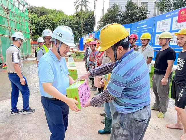 岑廷義為一線工人發放清涼飲品。 謝秋云 攝（650圖）.jpg